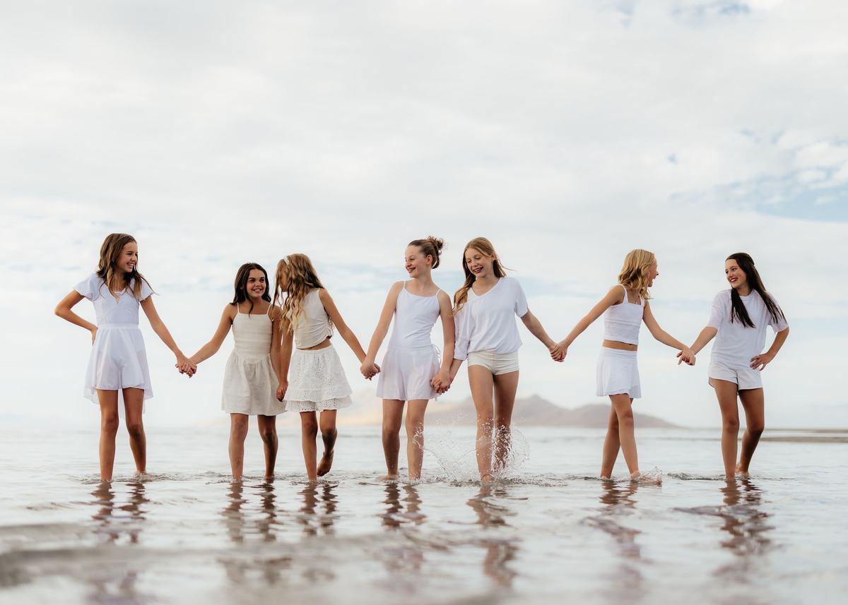 Anchor dancers walking hand in hand along the shoreline
