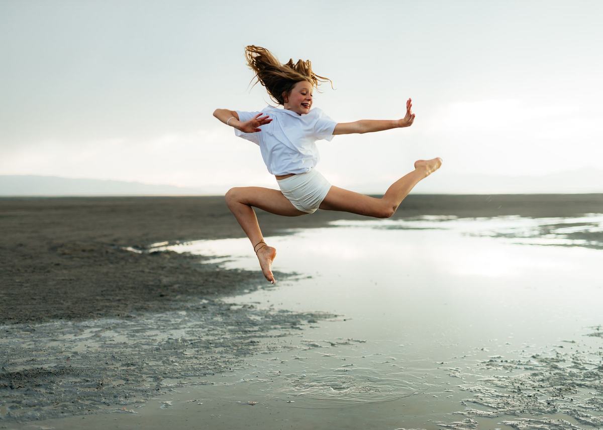 A dancer leaping joyfully across the water